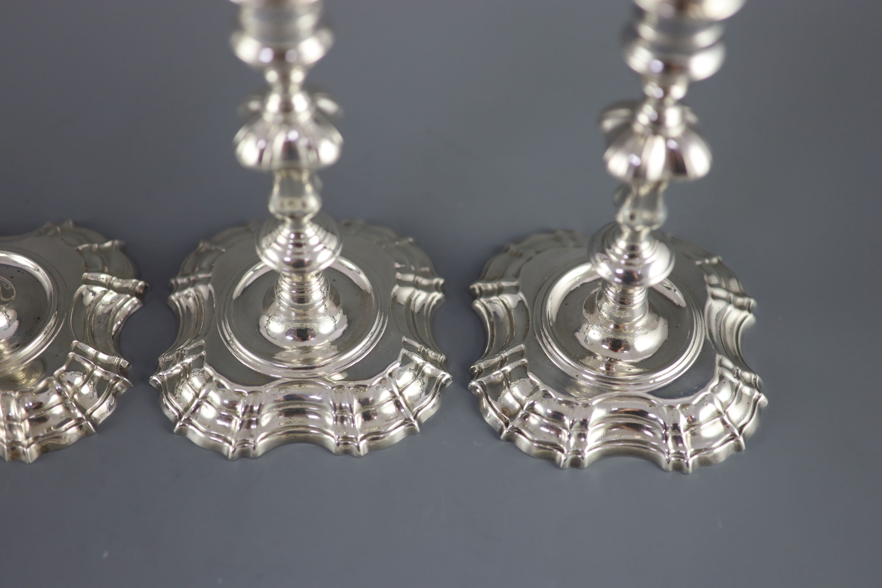 A near set of four George II cast silver candlesticks, by John Cafe